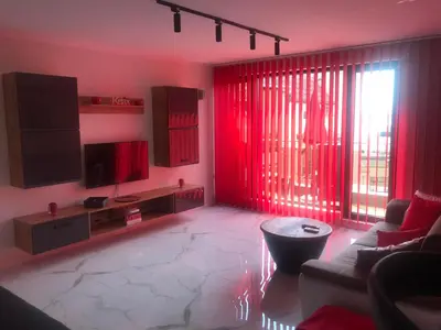 a living room with red curtains and a couch at Relax Apartment am Südstrand in Primorsko