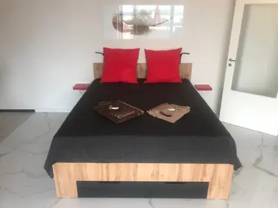 a bedroom with a bed with red pillows at Relax Apartment am Südstrand in Primorsko