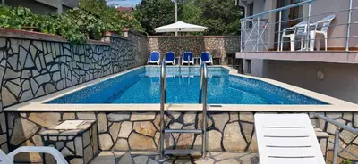 a swimming pool with two chairs and a swimming pool at Family hotel Favourite in Obzor
