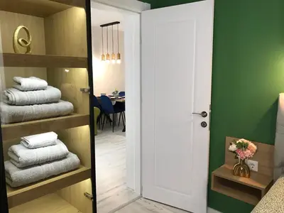a bathroom with a door open to a room with towels at Аpartment Bella Vista in Obzor