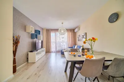 a dining room and living room with a table and chairs at Summertime in Varna South Bay Beach Residence in Varna City