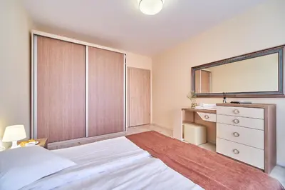a bedroom with a bed and a dresser and a mirror at Summertime in Varna South Bay Beach Residence in Varna City