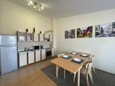 a kitchen and dining room with a table and a refrigerator at Green Fort - Prestige Sea Viev apartments in Sunny Beach