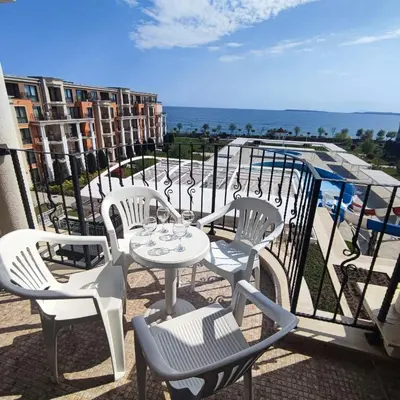 a patio with a table and chairs on a balcony at Premier Fort Beach Luxury in Sveti Vlas