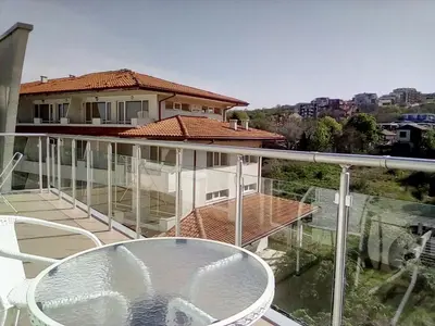 a balcony with a glass table and a house at Silver Beach A98 in Byala