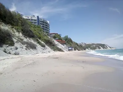 a beach with a building on the side of a hill at Silver Beach A98 in Byala