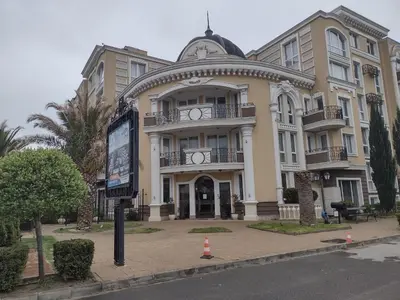 a large building on a street with a billboard in front of it at Messembria Palace Bulgaria in Sunny Beach