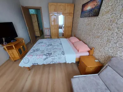 a bedroom with a bed and a couch and a television at Апартамент Кънтри-Лариса in Pomorie