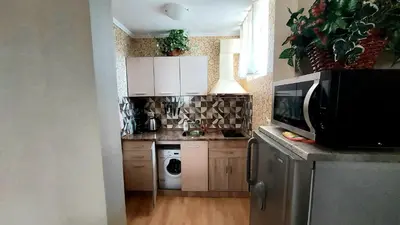 a kitchen with white cabinets and a microwave at Апартамент Кънтри-Лариса in Pomorie