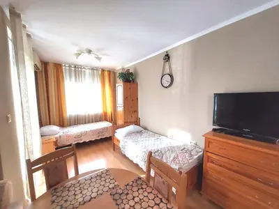 a living room with a television and a room with a table at Апартамент Кънтри-Лариса in Pomorie