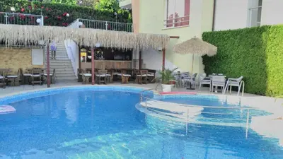 a large blue swimming pool with tables and chairs at Apartmán Alex beach s nádherným panoramatickým výhledem na moře in Sveti Vlas