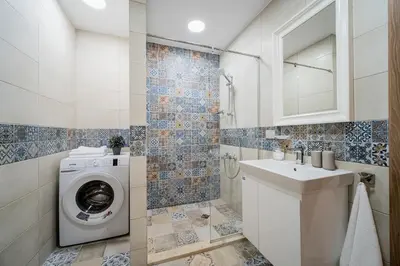 a bathroom with a washing machine and a sink at Comfy luxury center apartment in Varna City