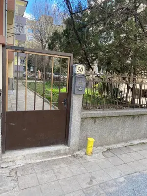 a parking meter next to a gate with a speed limit sign at Luxury family apartament in Burgas City