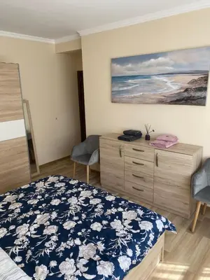 a bedroom with a bed and a painting on the wall at Luxury family apartament in Burgas City