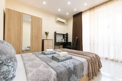 a bedroom with a bed with two pillows on it at BeCentral! by RV Apartments in Varna City