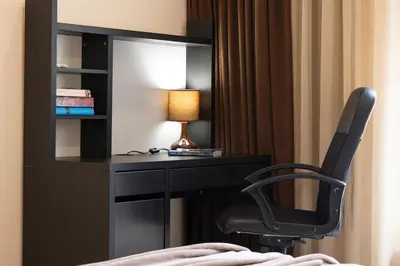a desk with a chair and a lamp in a room at BeCentral! by RV Apartments in Varna City