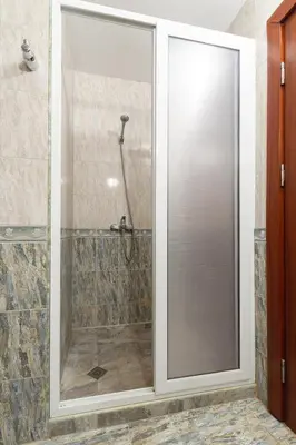 a shower with a glass door in a bathroom at BeCentral! by RV Apartments in Varna City
