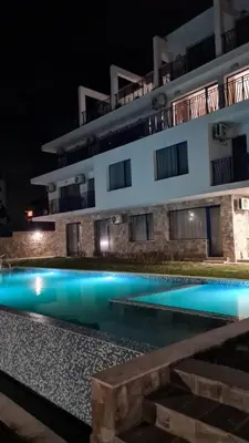 a building with a swimming pool at night at Вила Quiet Bay in Sozopol