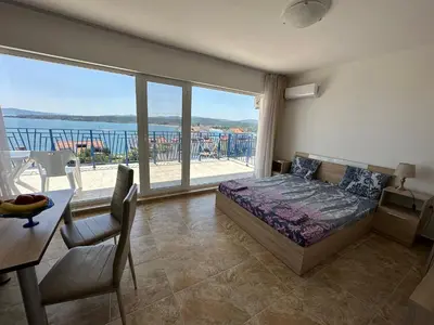 a bedroom with a bed and a large window at Вила Quiet Bay in Sozopol