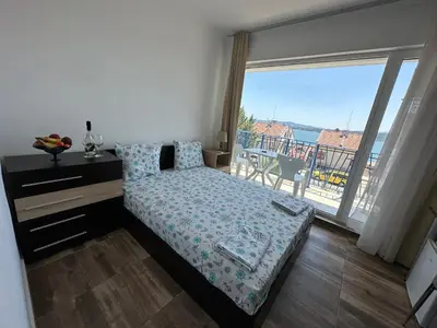 a bedroom with a bed and a large window at Вила Quiet Bay in Sozopol