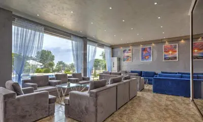 a large living room with couches and blue furniture at Студио Симона 2 - първа линия море in Lozenets