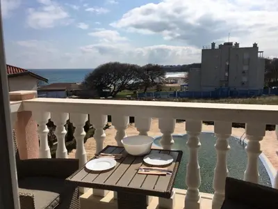 a table on a balcony with a view of the ocean at Студио Симона 2 - първа линия море in Lozenets