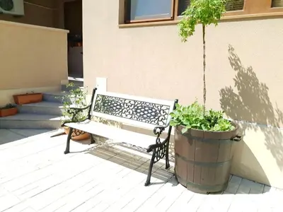 a bench sitting on a patio with a potted plant at Анси in Pomorie