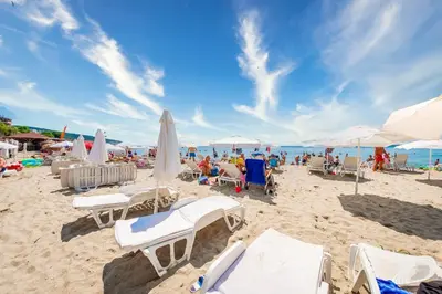 a beach with a lot of chairs and umbrellas at Prestige Fort Beach - Premium apartments in Sveti Vlas