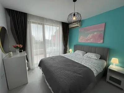 a bedroom with a bed and a blue wall at Prestige Fort Beach - Premium apartments in Sveti Vlas