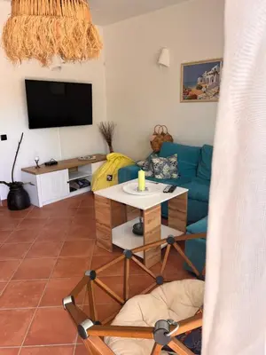 a living room with a blue couch and a tv at Villa Oasis етаж1 in Lozenets
