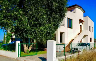 a white house with a tree in front of it at Villa Oasis етаж1 in Lozenets