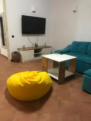 a living room with a couch and a yellow ottoman at Villa Oasis етаж1 in Lozenets