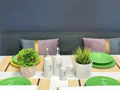 a table with green plates and bottles and plants on it at Апартамент Компас in Burgas City
