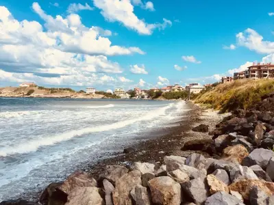 a beach with rocks and buildings in the background at Sea view apartment in Tsarevo