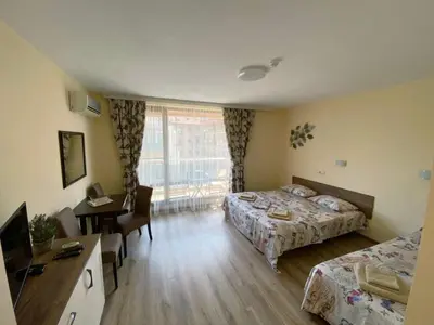 a hotel room with two beds and a desk at Студио-