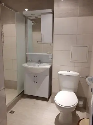 a bathroom with a white toilet and a sink at Студио-