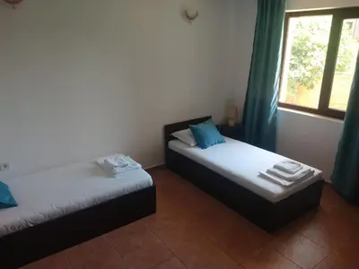 two beds in a room with a window at Къща за гости Валена град Черноморец in Chernomorets