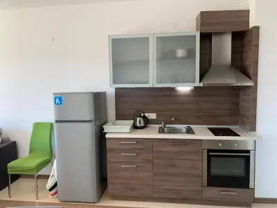a small kitchen with a refrigerator and a sink at Apartment at St. Nicholas Complex-Igora in Chernomorets