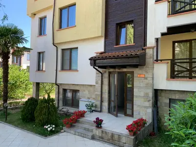 a building with red flowers in front of it at Apartment at St. Nicholas Complex-Igora in Chernomorets