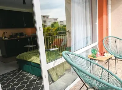 a balcony with two chairs and a table and a kitchen at Nessebar Fort Club - Prestige Apartments in Sunny Beach
