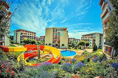 a garden with a swimming pool in a city at Sea Fort Club & Grand Resort in Sveti Vlas