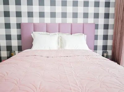 a bed with a pink comforter and white pillows at Sea Fort Club & Grand Resort in Sveti Vlas