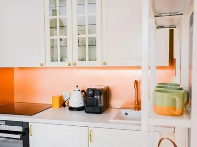 a kitchen with white cabinets and a counter top with a microwave at Sea Fort Club & Grand Resort in Sveti Vlas