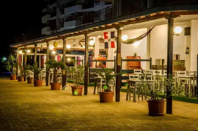 a restaurant with potted plants and tables and chairs at Grand Resort - Sea Viev and Premium Apartments in Sveti Vlas