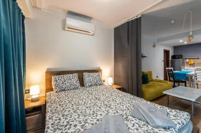 a bedroom with a bed and a living room at МЯСТОТО in Burgas City