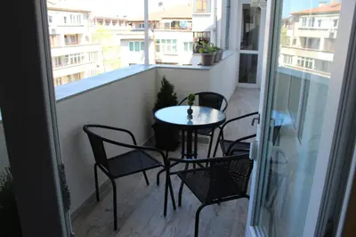 a small table and chairs on a balcony at МЯСТОТО in Burgas City