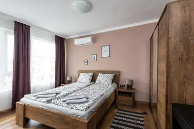 a bedroom with a bed and a large window at МЯСТОТО in Burgas City