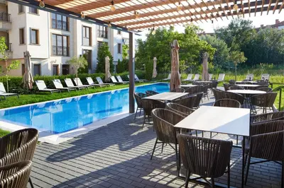 a restaurant with tables and chairs next to a swimming pool at Amara Sugar Hotel in Sunny Beach