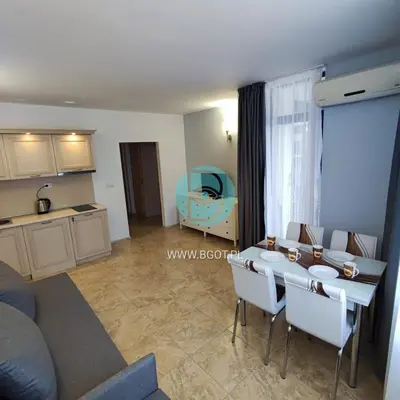 a kitchen and a living room with a table and chairs at AVALON premium apartments in Sunny Beach