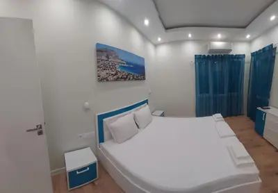 a bedroom with a white bed and a painting on the wall at Апартамент Pink & Blue - 2BDR with Balcony - Wi-Fi in Varna City